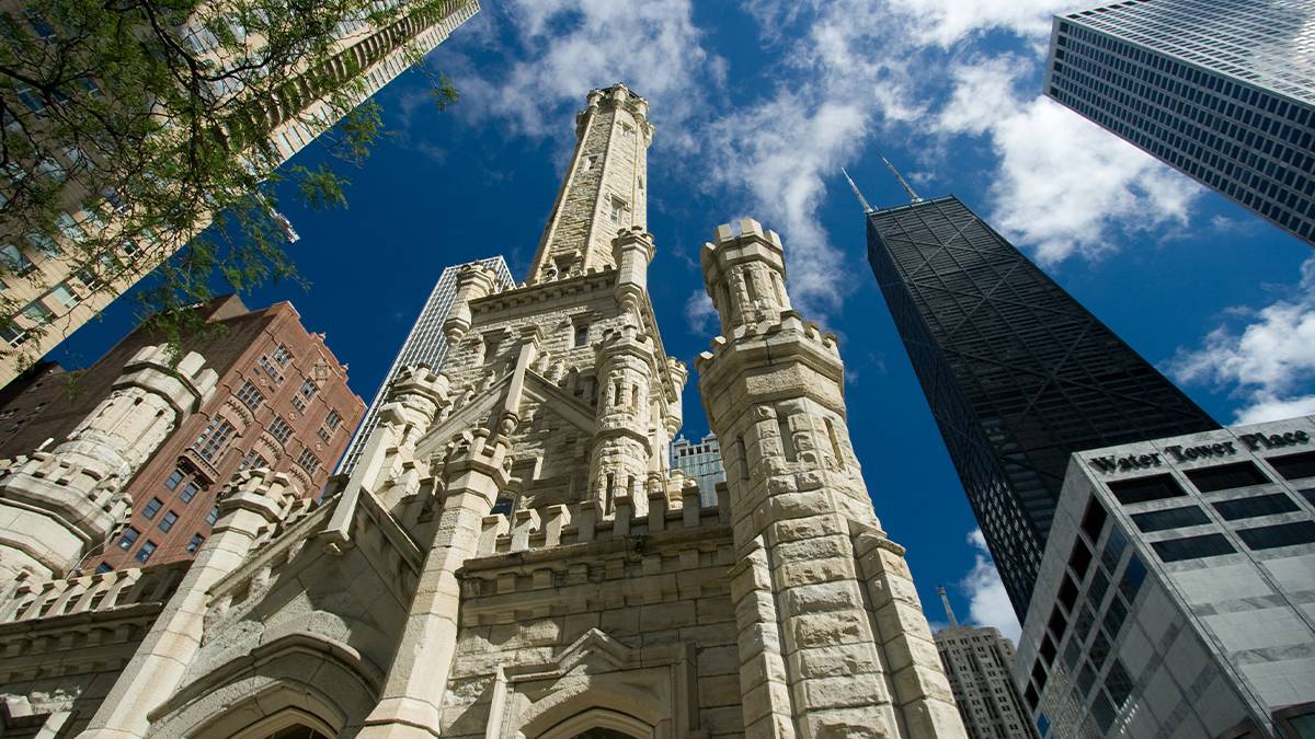 View looking up at the Chicago Water Tower with a blue sky and puffy clouds behind it in Chicago, Illinois, USA