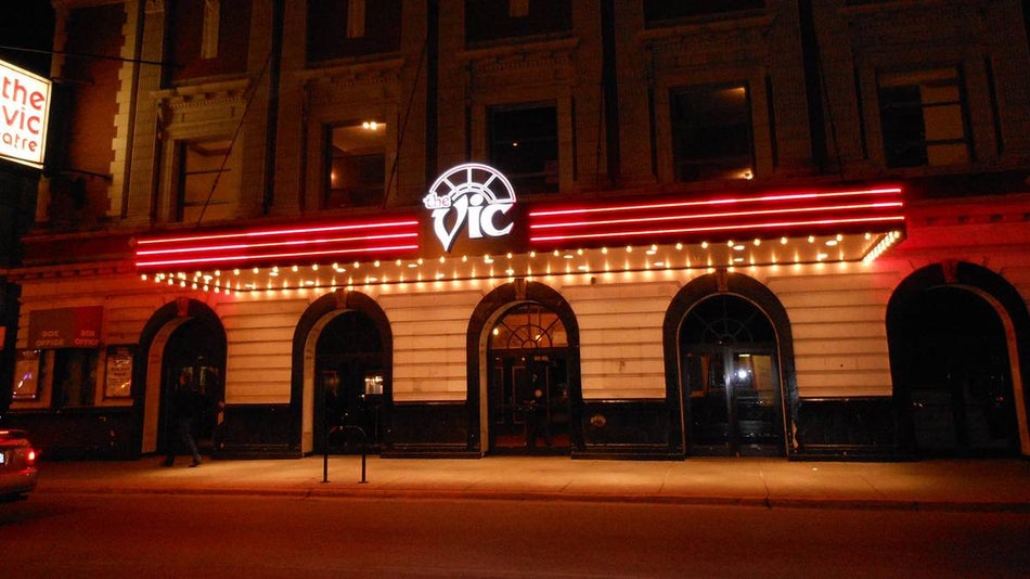 View of The Vic Theatre at night with their sign on and red neon lights running in Chicago, Illinois, USA