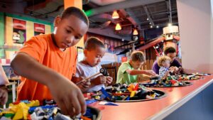 Close up of young boys building LEGO cars at the Vehicle Build and Test area at LEGOLAND Discovery Center in Chicago, Illinois, USA