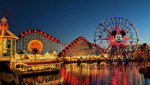 nightshot of Pixar Pier featuring Pixel Pal-Ar-ound ferris wheel and Incrediroster roller coaster in Disneyland, Anaheim, California, USA