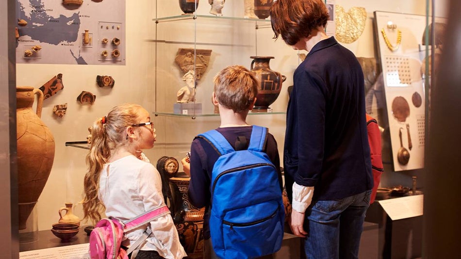 Close up of a family looking at a museum exhibit learning about history.