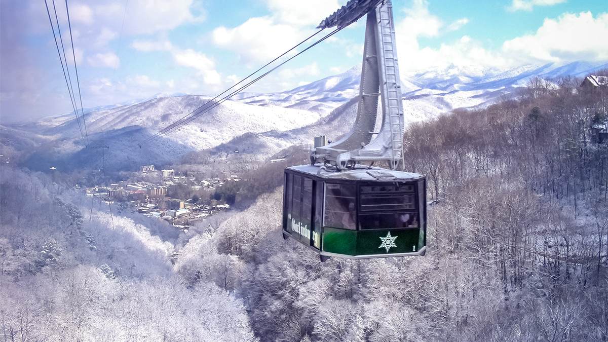 Close up view of the Aerial Tramway in motion at Ober Gatlinburg with the trees below covered in snow in Gatlinburg, Tennessee, USA