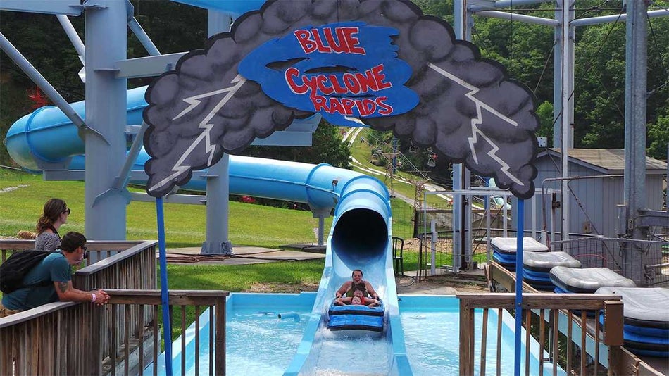 People splashing into the water at the bottom of Blue Cyclone Rapids waterslide at Ober Gatlinburg in Gatlinburg, Tennessee, USA