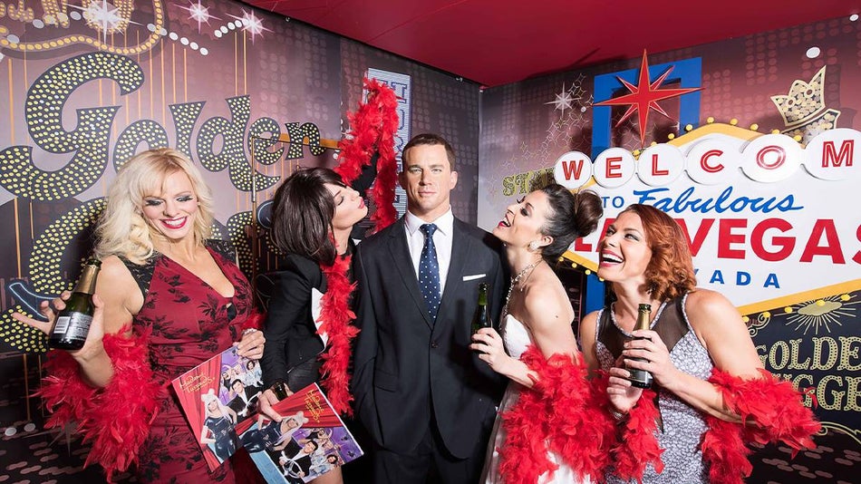 women with red fur boas and drinks posing with wax figure of Channing Tatum at Madame Tussauds in Las Vegas, Nevada, USA