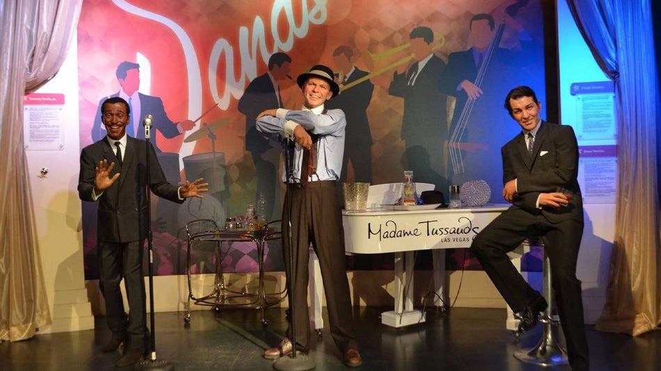 Wide shot of the wax figures of the Rat Pack posing with a piano and drinks at Madame Tussauds in Las Vegas, Nevada, USA