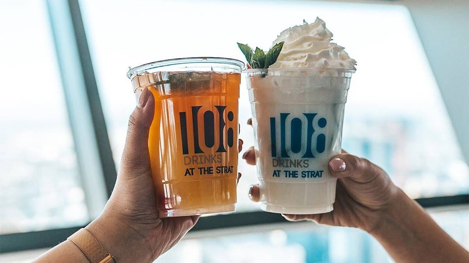 Two people cheering 108Drinks, one orange and the other white with shipped cream in Las Vegas, Nevada, USA