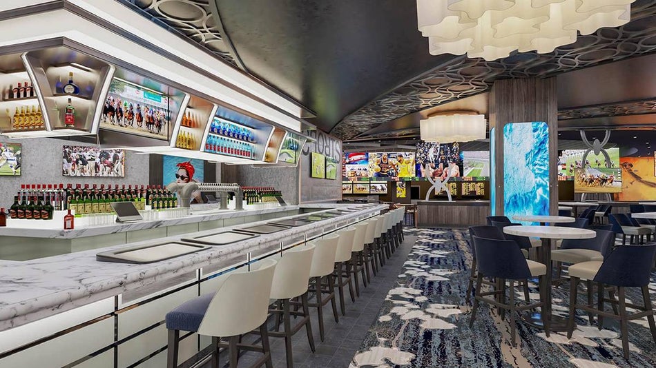 Wide shot of the View Lounge at SkyPod with a white marble bar with white chairs on the left and TVs lining the back wall in Las Vegas, Nevada, USA