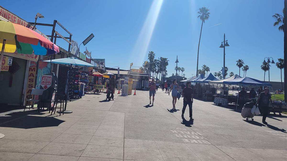 Wide shot of people walking and shopping at the farmers market at Venice Beach in Los Angeles, California, USA