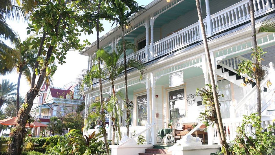 Close up of the front of the Southernmost Point Guest House, a light blue and white house with stairs on the front in Miami, Florida, USA.