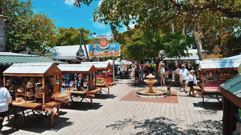 Wide shot of the Mallory Square Market with people shopping on a sunny day and several different vendors near Miami, Florida, USA