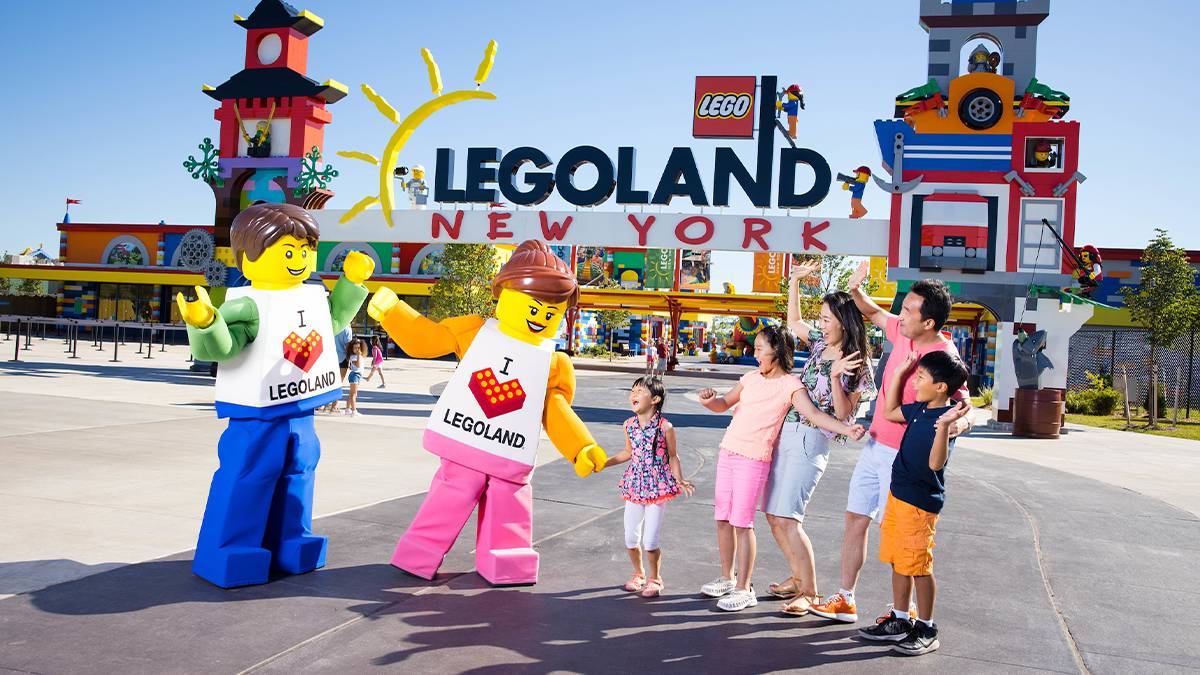 Wide shot of the entrance to LEGOLAND New York with two LEGO people standing with a family in front of it near NYC, New York, USA