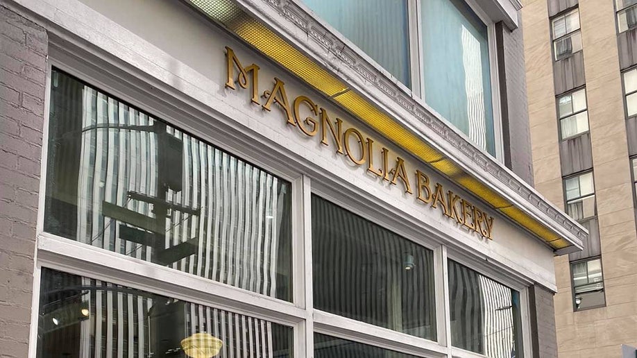 Sign ro Magnolia Bakery in gold lettering above their windows in NYC, New York, USA