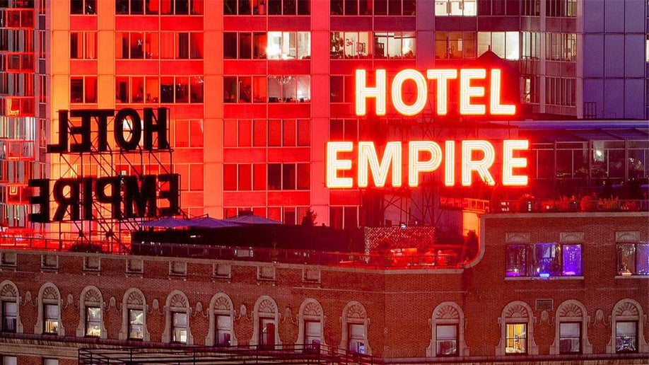 View of the neon sign for the Hotel Empire that sits on its roof at night in NYC, New York, USA