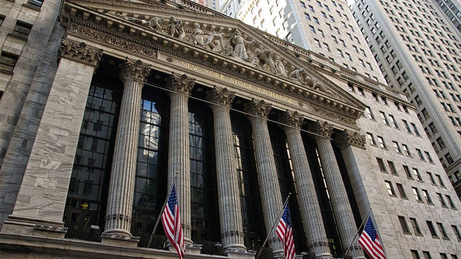 Looking up at the New York Stock Exchange from the street, a large stone building with columns, on a sunny day in NYC, New York, USA