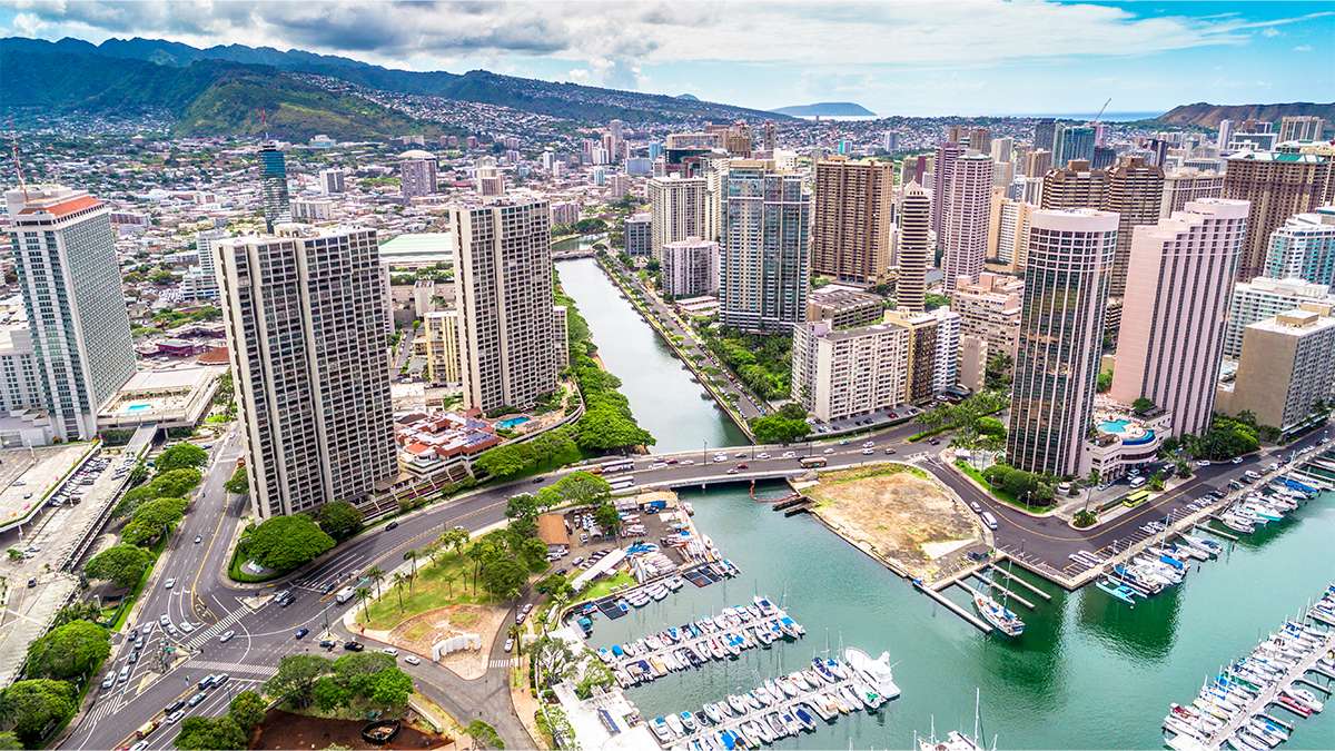 Aerial view of downtown Honolulu on a sunny in with mountains in the background on Oahu, Hawaii, USA