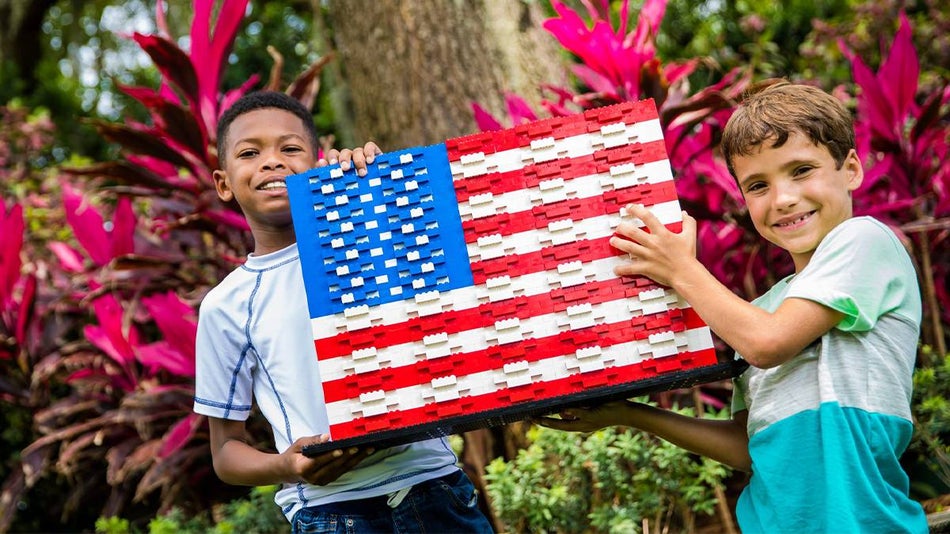 Two young boys holding a LEGO American flag for Red, White and Boom at LEGOLAND FLorida in Orlando, Florida, USA