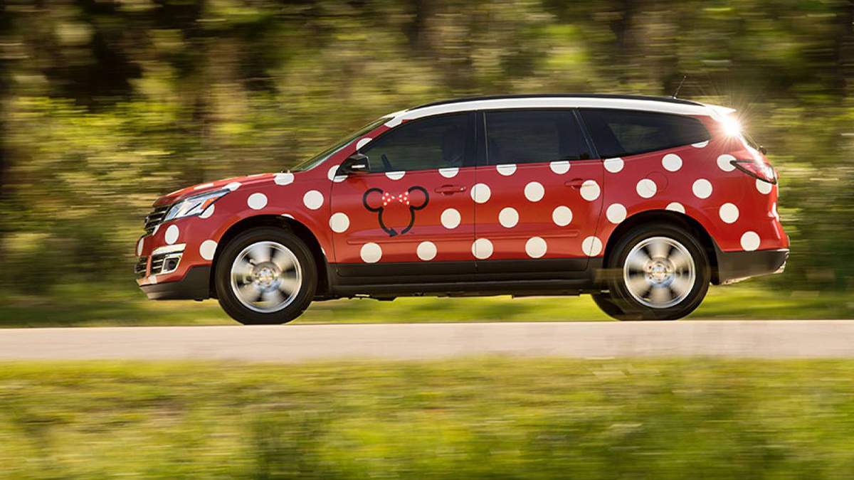 Close up for a Minnie Van with a Minnie logo on the drivers door driving on a sunny day in Orlando, Florida, USA