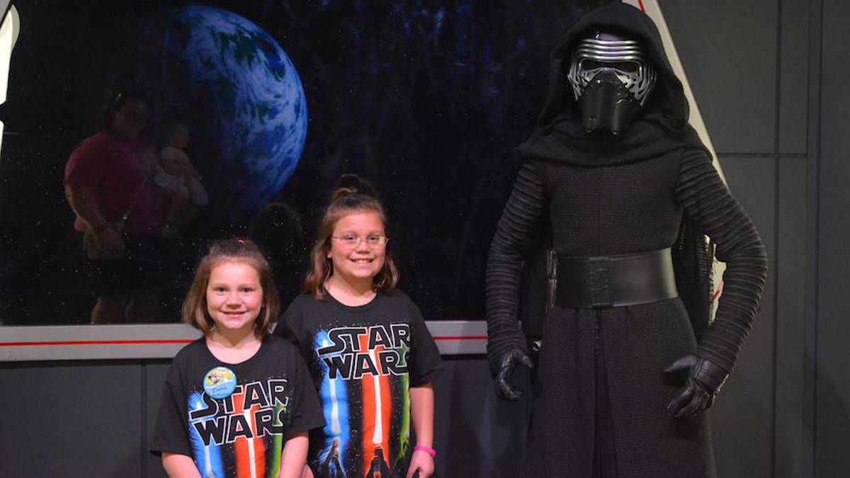 Two young girls in Star Wars t shrits standing next to Kylo Ren at a Star Wars Meet and Greet in Orlando, Florida, USA