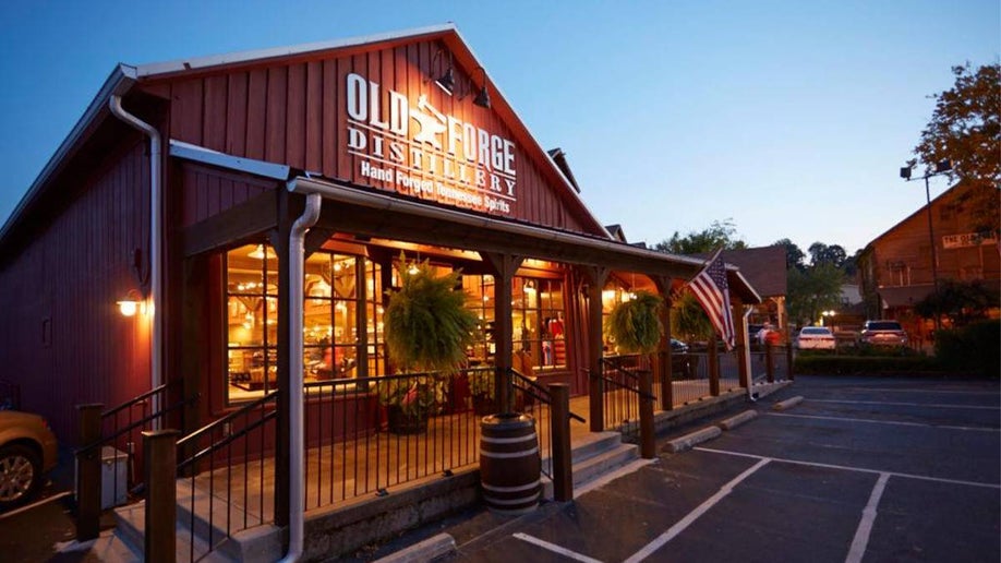 Wide shot of the exterior of the Old Forge Distillery at dusk with their lights on inside in Pigeon Forge, Tennessee, USA