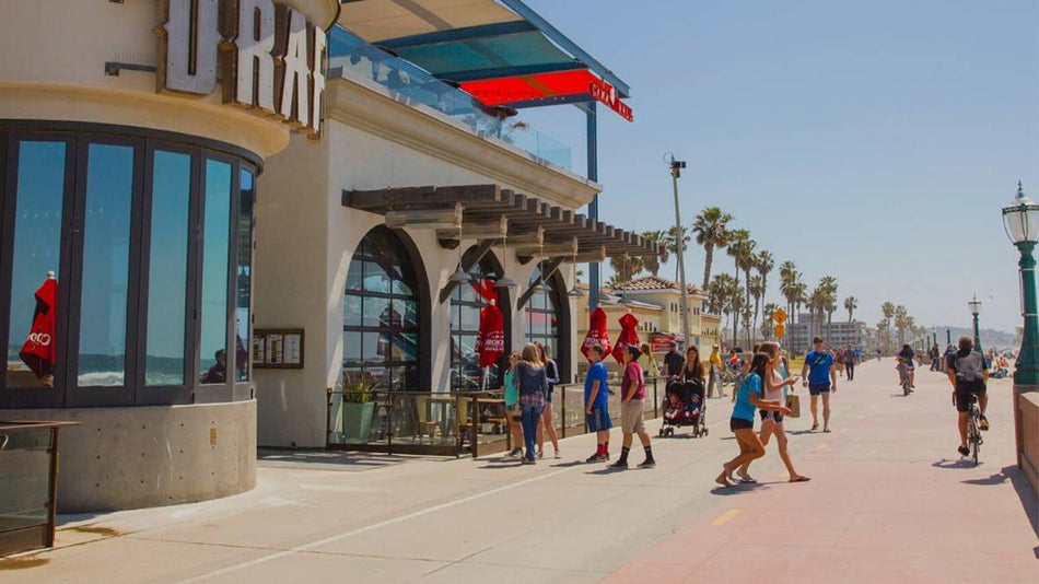 Wide shot of the Mission Beach Boardwalk on a busy sunny day in San Diego, California, USA