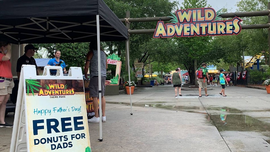 The entrance to Wild Adventures Theme Park with a sign for free donuts for dad for Father's Day in Savannah, Georgia, USA