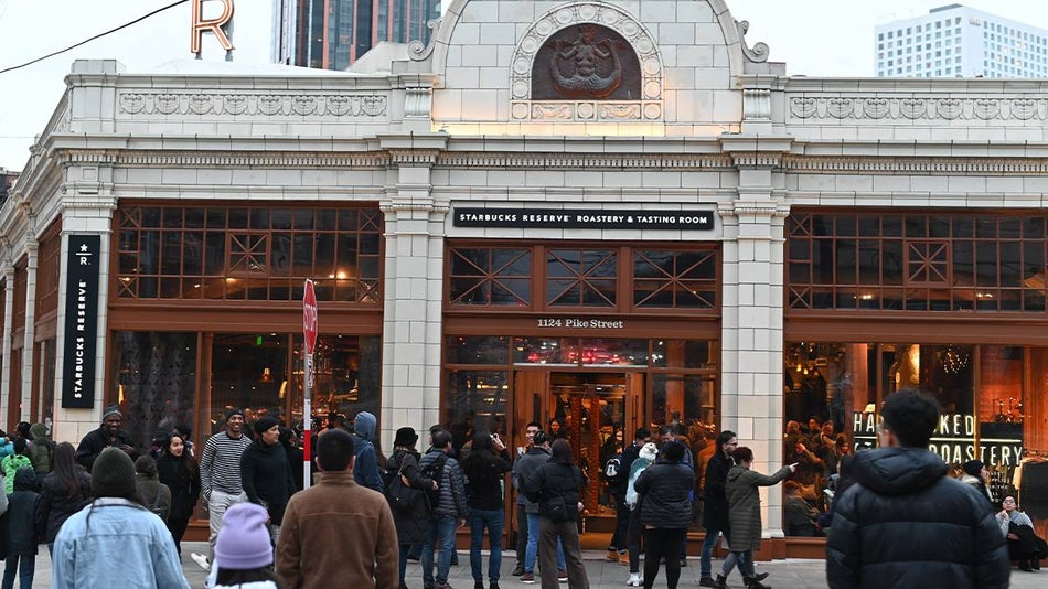 View of the white stone exterior of the Starbucks Reserve Roastery with a crowd of people surrounding it in Seattle, Washington, USA