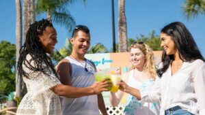 Close up photo of four friends cheering drinks at Adventure Island on a sunny day in Tampa, Florida, USA