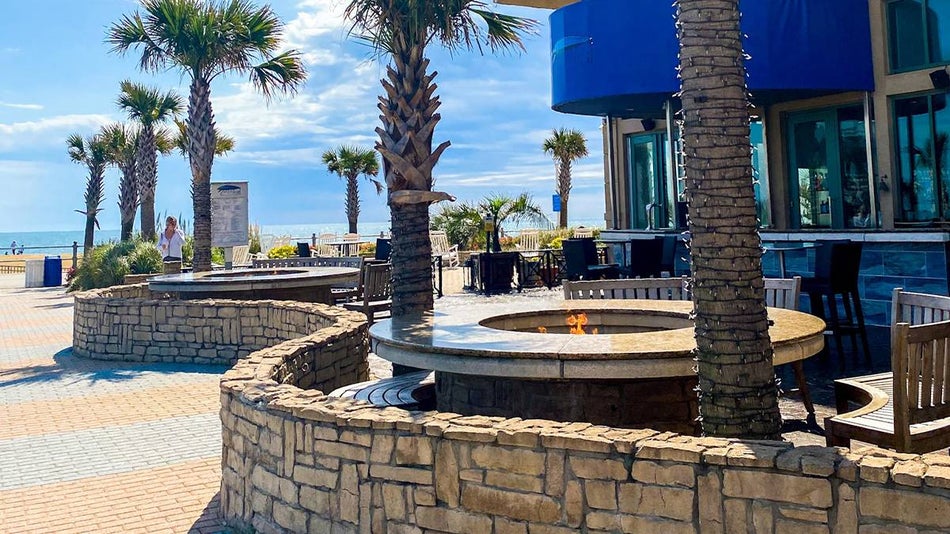 View of the outdoor dining area and fire pit at Catch 31 Fish House and Bar in Virginia Beach, Virginia, USA
