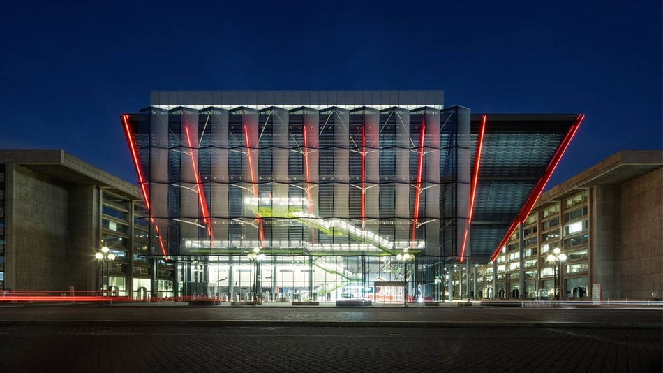 Wide shot of the exterior of the International Spy Museum with their red lights on at night in Washington, D.C., USA